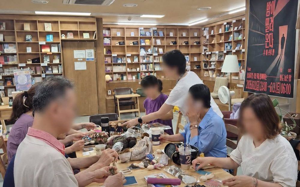 긴 테이블에 둘러앉아 비모임을 하는 사람들